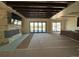 Spacious living room with stone fireplace, wood beam ceiling, and access to the outdoor space through sliding glass doors at 1555 Arrowpoint Ct, Franktown, CO 80116