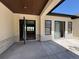 Covered patio featuring stone accents, a coffered wood ceiling, and glass doors providing an indoor/outdoor living space at 1555 Arrowpoint Ct, Franktown, CO 80116