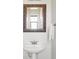 Bathroom with a white pedestal sink, ornate mirror, and neutral walls at 7440 E 8Th Ave # 25, Denver, CO 80230