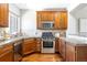 Well-maintained kitchen featuring stainless steel appliances, wooden cabinets, and granite countertops at 7440 E 8Th Ave # 25, Denver, CO 80230