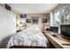 A cozy bedroom featuring floral bedding, a white closet door, and bright natural light from the window at 9741 Chambers Dr, Commerce City, CO 80022