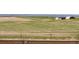 Vast grassy field featuring a distant home with open space perfect for recreational activities at 9741 Chambers Dr, Commerce City, CO 80022