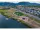 Aerial view of lakeside park, community, and waterway complete with an amphitheater and walking paths at 2573 Lakes Edge Dr, Monument, CO 80132