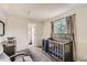 Bedroom featuring a crib, with direct access to an ensuite bathroom at 4567 Flanders Way, Denver, CO 80249
