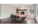 Dining room with brick fireplace, decorative mantle, hardwood floors, and a modern dining table at 4567 Flanders Way, Denver, CO 80249