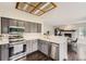 Bright kitchen with stainless appliances, gray cabinets, and an open layout flowing into dining area at 4567 Flanders Way, Denver, CO 80249