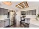 Modern kitchen featuring stainless steel appliances, dark wood floors, and stylish gray cabinetry at 4567 Flanders Way, Denver, CO 80249