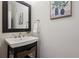 Stylish half-bathroom featuring a modern sink, dark mirror, and tasteful decor at 6687 S Forest Way # E, Centennial, CO 80121