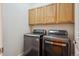 The laundry room features matching washer and dryer units and oak cabinets at 6687 S Forest Way # E, Centennial, CO 80121