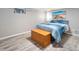 Cozy bedroom with a blue bed set, a wooden chest, and wood-look flooring at 2995 Albion St, Denver, CO 80207