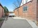 Brick exterior featuring a large concrete driveway with a trailer parked at the end at 2995 Albion St, Denver, CO 80207