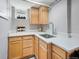 Kitchenette featuring light wood cabinets, white countertops, and a stainless steel sink at 2995 Albion St, Denver, CO 80207
