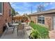 Outdoor patio with a table and chairs, lounging furniture, and lush greenery at 2995 Albion St, Denver, CO 80207