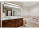 Bathroom with dual sinks, vanity, large mirror and soaking tub at 13950 E Oxford Pl # B105, Aurora, CO 80014