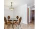 A formal dining area with a glass table set for four beneath a decorative pendant light fixture at 13950 E Oxford Pl # B105, Aurora, CO 80014