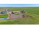 Expansive aerial view of a home with a fenced yard and basketball court in a lush, green, rural setting at 42073 Colonial Trl, Elizabeth, CO 80107