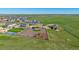 Aerial view featuring a fenced yard, basketball court, and residences within a green, sprawling community at 42073 Colonial Trl, Elizabeth, CO 80107