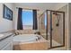 Bathroom with a soaking tub, glass enclosed shower, and granite countertops at 42073 Colonial Trl, Elizabeth, CO 80107