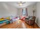 Cozy bedroom featuring hardwood floors, a ceiling fan, and a white wood crib at 42073 Colonial Trl, Elizabeth, CO 80107