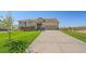 Inviting home boasts a lush green lawn and long concrete driveway leading to a two-car garage at 42073 Colonial Trl, Elizabeth, CO 80107