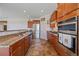 Open kitchen with wood cabinets, stainless steel appliances, granite countertops, and tile floors at 42073 Colonial Trl, Elizabeth, CO 80107