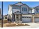 Two-story home boasts gray siding, stone accents, covered entryway, and attached two-car garage at 6635 N Nepal St, Aurora, CO 80019