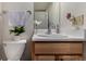 Bright bathroom features a toilet and a vanity with sink, complemented by a houseplant at 1152 S Yosemite Way # 29, Denver, CO 80247