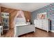 Bright bedroom showcases a white dresser, nightstand, and decoratively papered accent wall, complemented by hardwood floors at 1152 S Yosemite Way # 29, Denver, CO 80247