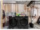 Functional laundry room featuring dual black Samsung machines, shelving, and essential laundry supplies at 1152 S Yosemite Way # 29, Denver, CO 80247