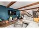 Open-concept living area with wood beams, a fireplace, TV, stylish decor, and stairs leading to the second floor at 1152 S Yosemite Way # 29, Denver, CO 80247