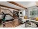 Bright and airy living room featuring wood beams, a staircase, a stylish sofa, and ample natural light at 1152 S Yosemite Way # 29, Denver, CO 80247