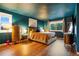 A main bedroom with wood floors and dark teal colored walls with two large windows at 1152 S Yosemite Way # 29, Denver, CO 80247