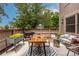 Outdoor patio with a wood table, seating, grill, and decorative rug and plants; ideal for entertaining or relaxing at 1152 S Yosemite Way # 29, Denver, CO 80247