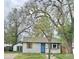 Charming single-story home with white siding, a bright blue front door, and mature trees in the front yard at 4745 S Sherman St, Englewood, CO 80113
