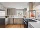 Updated kitchen with gray cabinetry, stainless steel appliances, and view into the living space at 4745 S Sherman St, Englewood, CO 80113