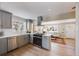Modern kitchen featuring stainless steel appliances, gray cabinets, and an open layout into the living space at 4745 S Sherman St, Englewood, CO 80113