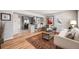 Open-concept living room and kitchen with hardwood floors, a comfortable sofa, and modern decor at 4745 S Sherman St, Englewood, CO 80113