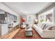 Inviting living area with hardwood floors, a bay window, a sofa, and a view into the updated kitchen at 4745 S Sherman St, Englewood, CO 80113
