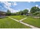 Expansive backyard with lush green lawn and mature trees, perfect for outdoor activities at 675 Holland St, Lakewood, CO 80215