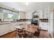 Eat-in kitchen featuring white cabinets, wood floors, and an abundance of natural light at 675 Holland St, Lakewood, CO 80215