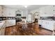 Eat-in kitchen showcasing wood floors, an island, and classic white cabinetry at 675 Holland St, Lakewood, CO 80215