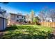Expansive backyard featuring a large deck, mature trees, lush lawn, and storage shed at 7083 Leopard Dr, Lone Tree, CO 80124