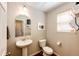 Cozy half bathroom with pedestal sink, wood look floors, and soft, neutral color palette at 7083 Leopard Dr, Lone Tree, CO 80124