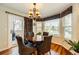 Breakfast nook with wood table, upholstered chairs, many windows, and sliding door to patio at 7083 Leopard Dr, Lone Tree, CO 80124