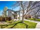 Charming two-story home with a well-manicured lawn, tree, and front yard at 7083 Leopard Dr, Lone Tree, CO 80124
