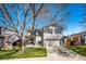 Charming two-story home with a well-manicured lawn, tree, and a two-car garage on a sunny day at 7083 Leopard Dr, Lone Tree, CO 80124