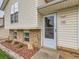 Close-up of the front door with brick accents, well-manicured landscaping, and neutral siding at 380 S 25Th Ave, Brighton, CO 80601