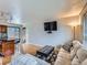 Open-concept living room featuring hardwood floors, a modern sofa, and access to the kitchen at 380 S 25Th Ave, Brighton, CO 80601