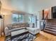 Cozy living room with hardwood floors, a comfortable couch, and a staircase leading to the upper level at 380 S 25Th Ave, Brighton, CO 80601