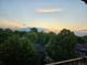 Scenic sunset view overlooking lush green trees and neighborhood rooftops from the balcony at 1313 Steele St # 606, Denver, CO 80206